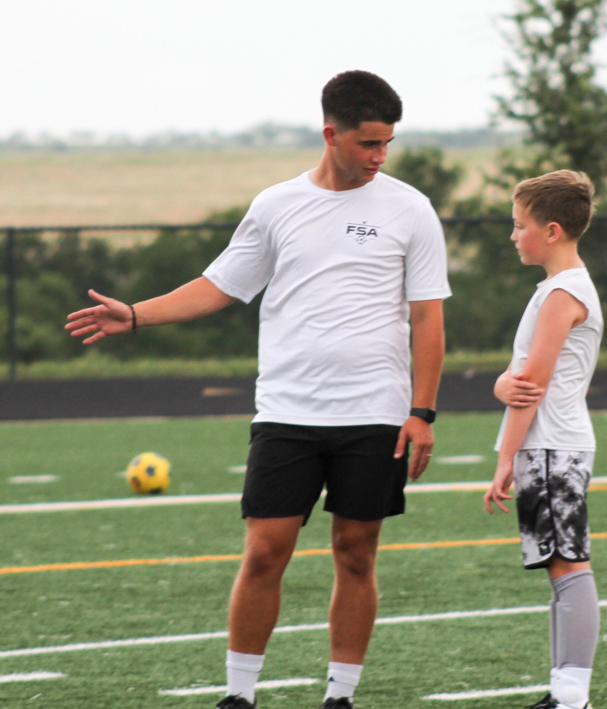 Coach Jose giving direction to a young FSA player during a training session